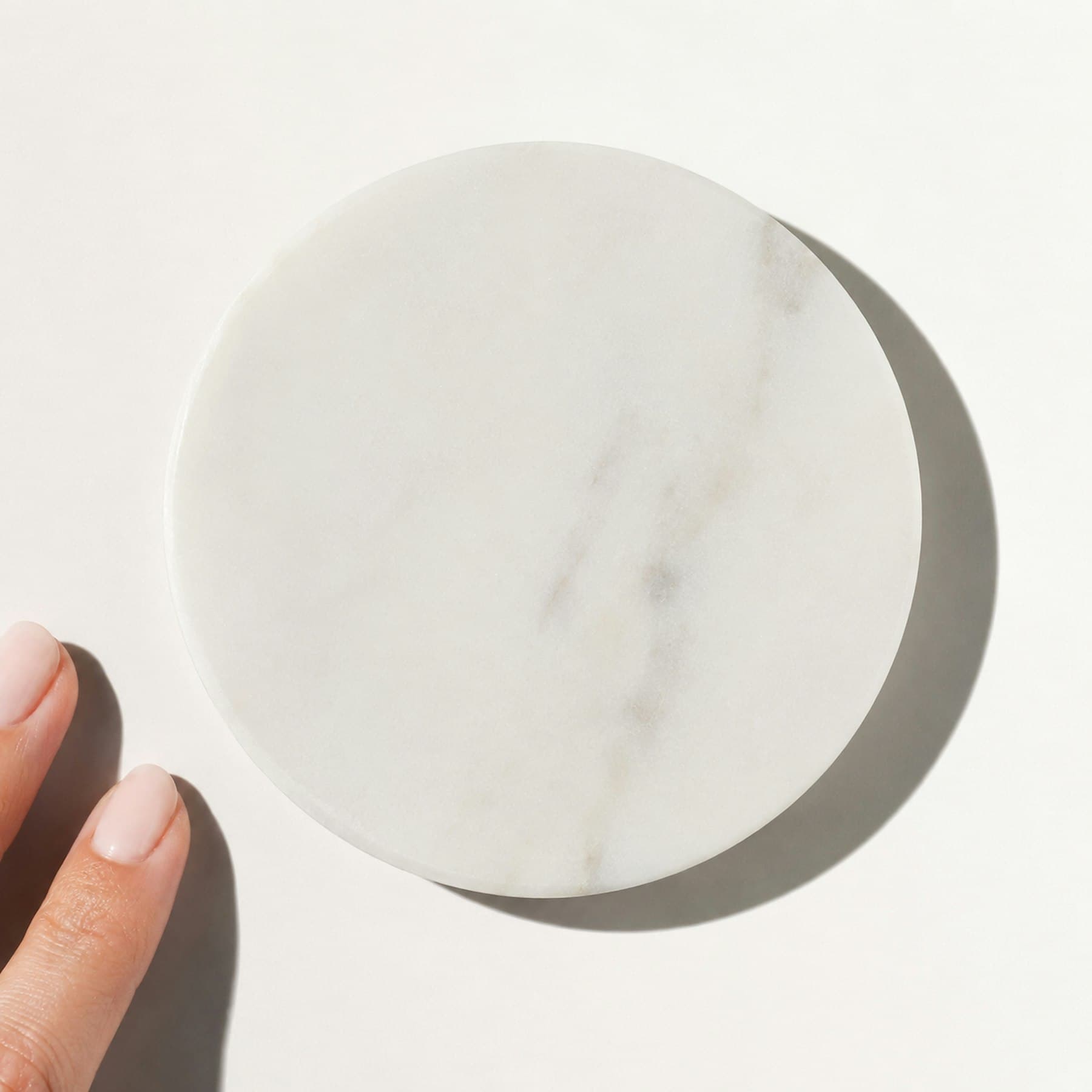 A round white marble coaster